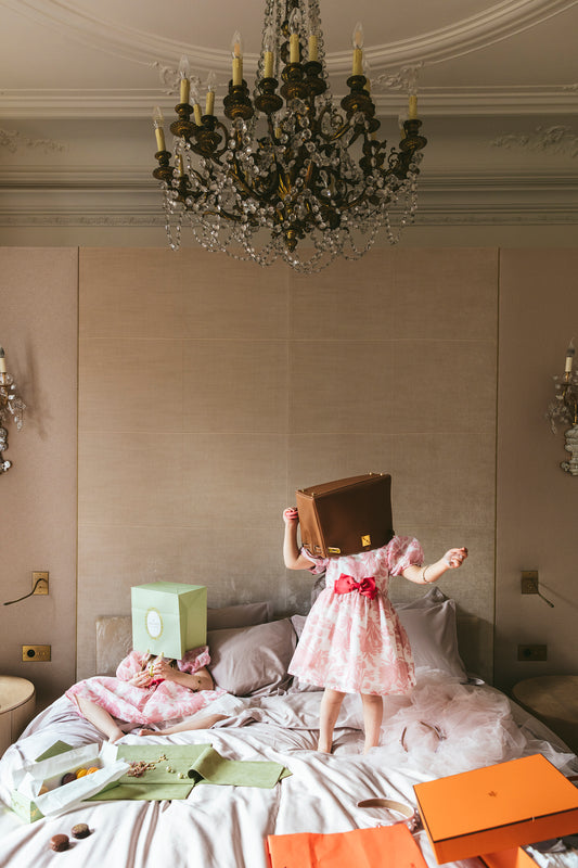 two girls on bed with bags on their heads. 