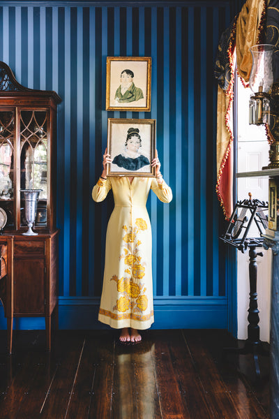 girl holding framed image in blue room