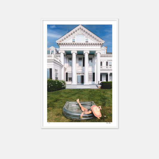 Large white house with inflatable pool and woman in bikini relaxing 