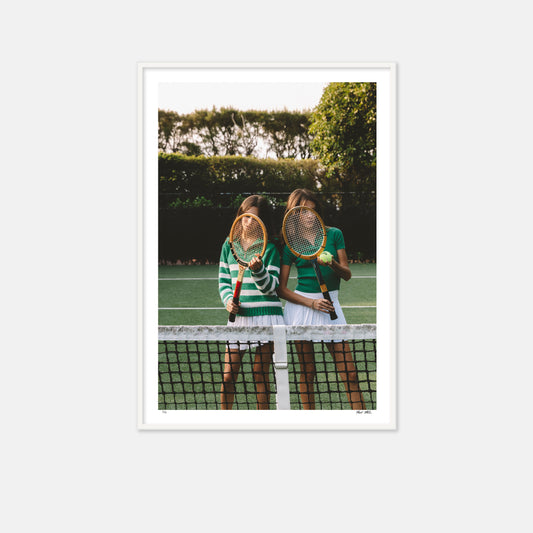 Twin girls with vintage racquets on tennis court