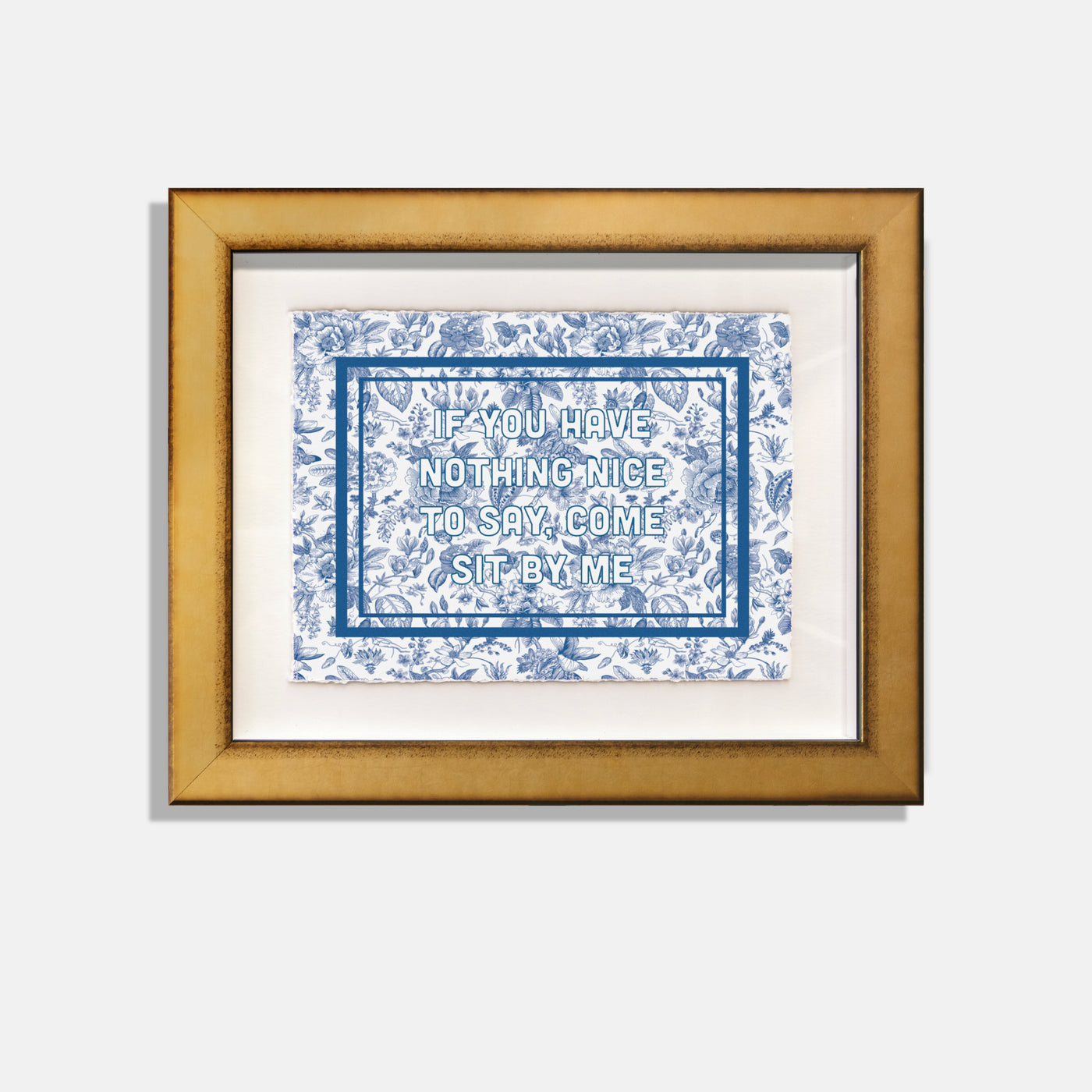 blue floral botanical print with text "if you have nothing nice to say come sit by me." in gold frame