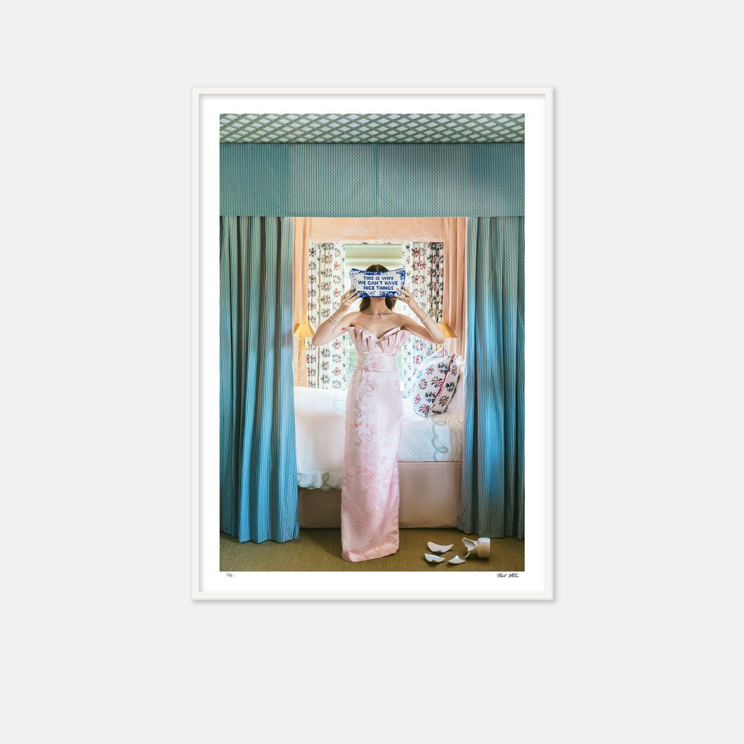 woman in pink dress next to a draped bed with a pillow in front of her face that says this is why we cant have nice things