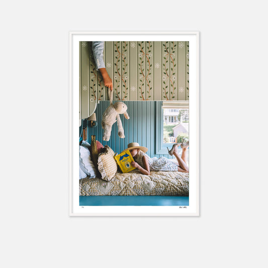 A little girl reading on bottom of bunkbed. A little boy is on the ned above trying to distract her with a teddy bear