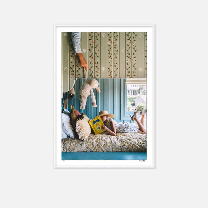A little girl reading on bottom of bunkbed. A little boy is on the ned above trying to distract her with a teddy bear