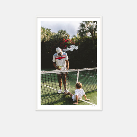 Tennis pro with young boy on tennis court