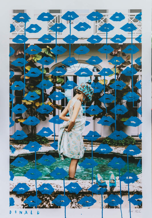 Woman standing in front of a decorative wall with blue lips and a pool.