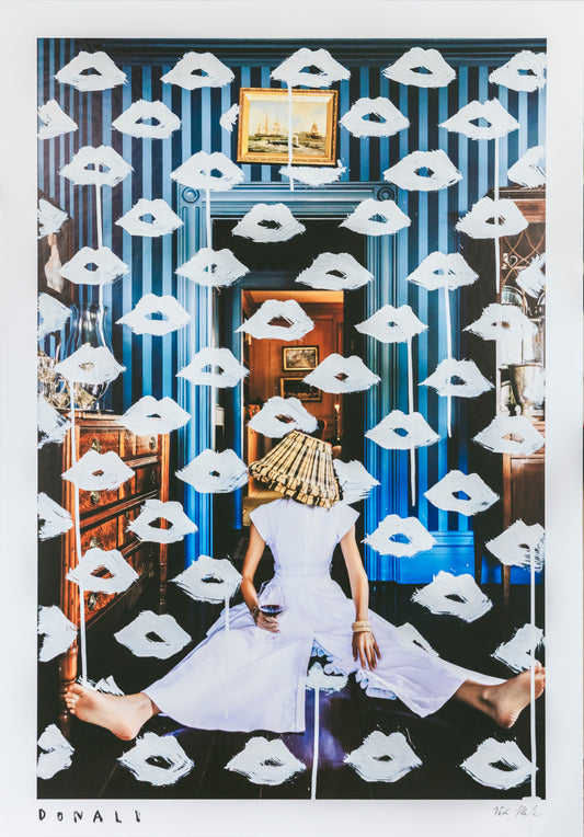 Woman in a white dress sitting on the floor with white masks around her, in a room with blue walls and a mirror.