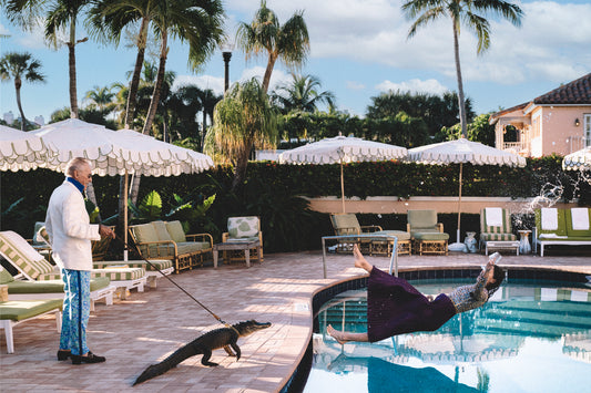 Man with alligator on leash as girl falls into pool with cocktail