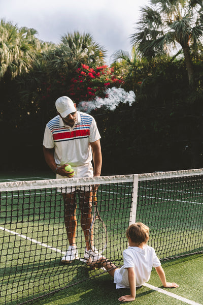 Tennis pro with young boy on tennis court