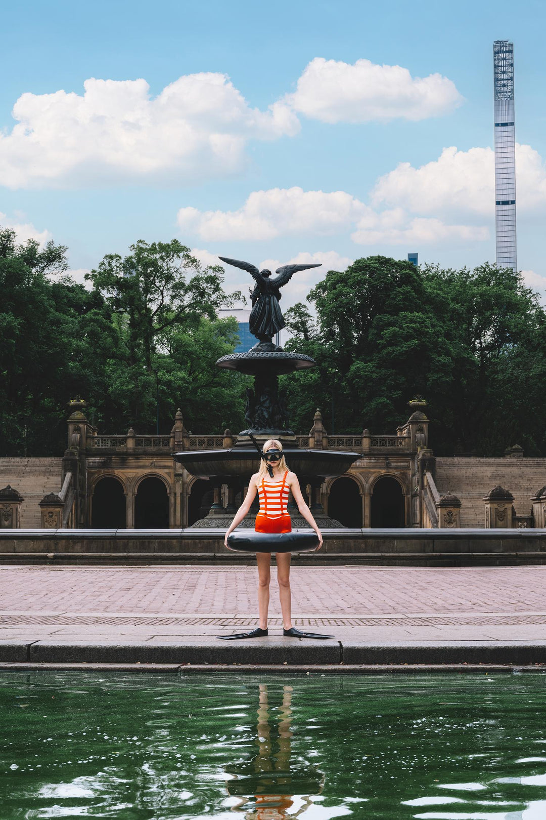 Swimmer in snorkel, fins and inner tube at Bethesda Fountain, Central Park. Nick Mele x Bergdorf Goodman, A New York Affair
