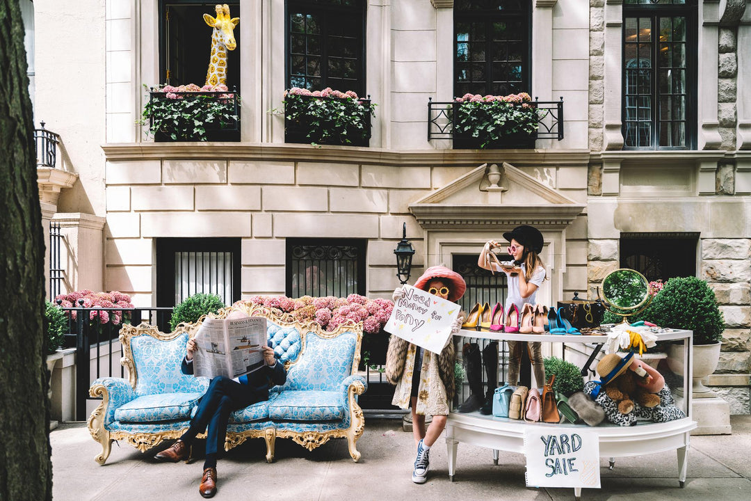 Townhouse yard sale with a blue rococo sofa, designer shoes and a giraffe in the window. Nick Mele x Bergdorf Goodman